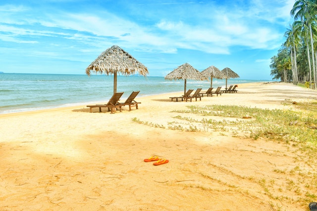 Odľahlá pláž so slnečníkmi a ležadlami pre turistov