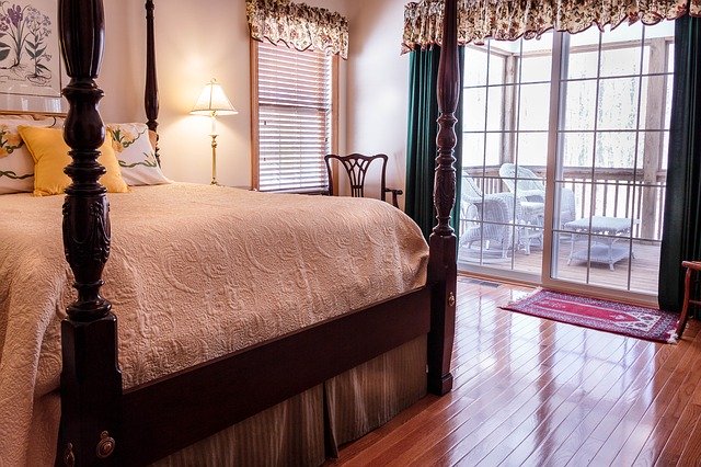Spálňa s manželskou posteľou a veľkými sklenenými dverami vedúcimi na balkón.jpg